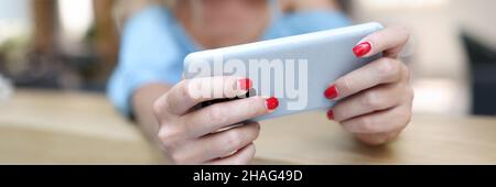 Lächelnde Frau mit Smartphone. Installation der Telefon-App Stockfoto