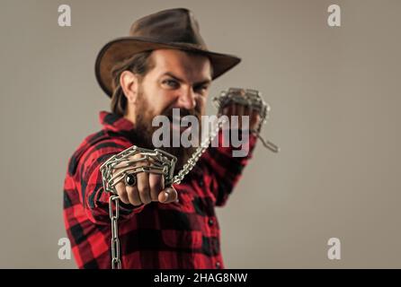 Cowboy mit Bart und Schnurrbart Stahlkette ziehen, Platz kopieren, einfangen Stockfoto