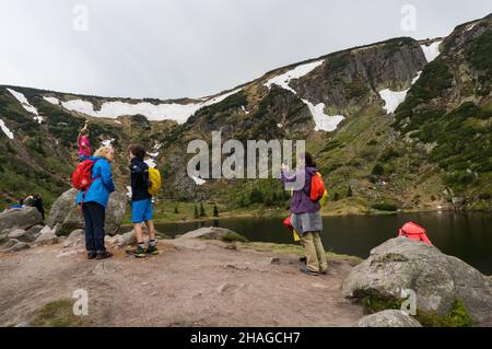 KARPACZ, POLEN - 09. Mai 2018: Die Gruppe von Menschen, die an einem See im Karkonosze-Gebirge stehen. Stockfoto