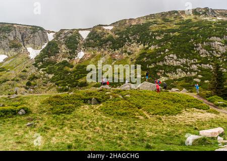 KARPACZ, POLEN - 09. Mai 2018: Die Menschen, die auf einem Fußweg durch hohe Hügel im Karkonosze-Gebirge wandern. Stockfoto