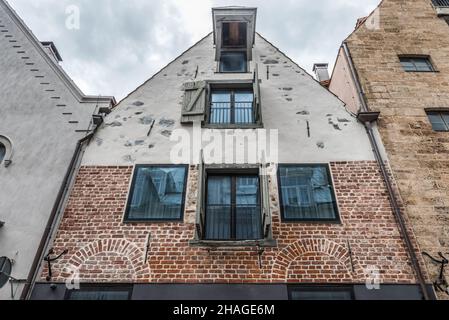 Riga, Lettland - 21. Mai 2021: Fassade eines alten Industriegebäudes ein altes Lagerhaus mit großen Fenstern und Toren. Straße von Riga, Lettland. Stockfoto