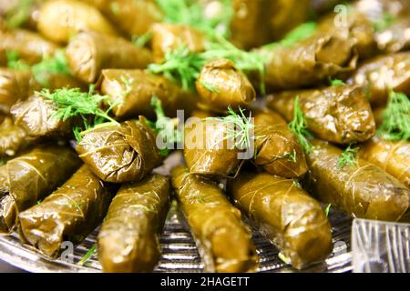 Nahaufnahme des Sarma-Tellers (auch Warak Enab oder Dolma) – Weinblätter, die um eine Füllung aus Reis und Hackfleisch gewickelt sind Stockfoto