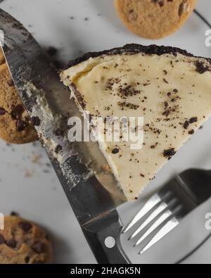 Draufsicht auf hausgemachten Chocolate Chip Cookie Teigkäsekuchen mit Messer und Gabel auf einem Teller Stockfoto