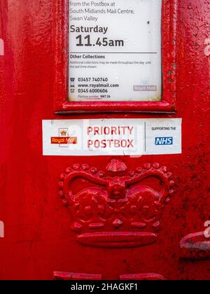 Prio Postbox Aufkleber auf einem Royal Mail Postkasten, der für die Veröffentlichung von Coronavirus-Tests verwendet wird, Hackleton, Northamptonshire, Großbritannien Stockfoto