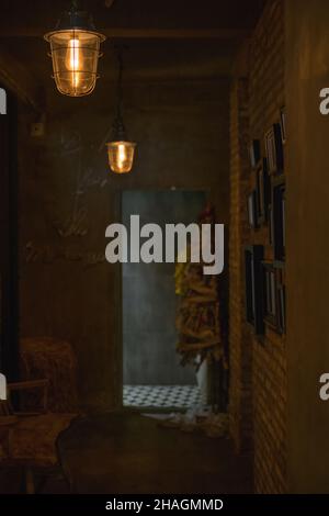 Dunkler Saal im Café mit antiken Lampen. Bilder an der Wand. Café-Innenausstattung. Hochwertige Fotos Stockfoto
