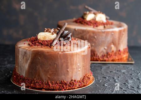 Bananen- und Schokoladenkuchen auf dunklem Hintergrund. Horizontale Ansicht. Feier-Kuchen aus nächster Nähe Stockfoto