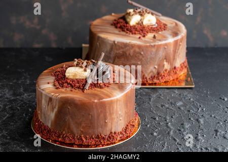 Bananen- und Schokoladenkuchen auf dunklem Hintergrund. Horizontale Ansicht. Feier-Kuchen aus nächster Nähe Stockfoto