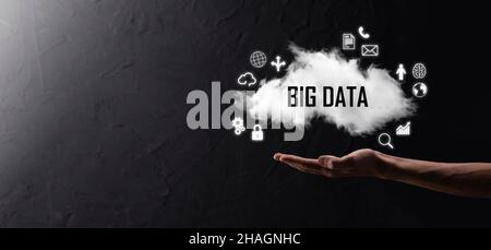 Geschäftsmann hält die Inschrift , Wort BIG DATA . Vorhängeschloss, Gehirn, Mann, Planet, Graph, Lupe, Zahnräder, Symbol für Cloud, Grid, Dokument, Brief, Telefon Stockfoto