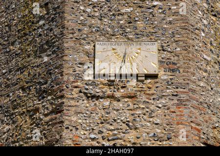 Modernes Sonnenrad an der Kirchenwand, Ashby, Suffolk, England, Großbritannien, „Ziel höher als das Mark“ Stockfoto