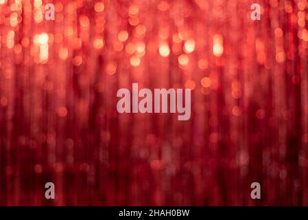 Festlicher roter Hintergrund mit Lametta unscharf und schönem Bokeh Stockfoto