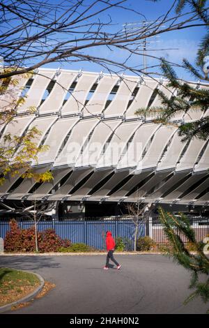 Ein Mann in einem roten Hoodie geht am Grandstand Stadium im USTA Billie jean King National Tennis Center im Flushing Meadows Corona Park in Queens, NYC, vorbei. Stockfoto