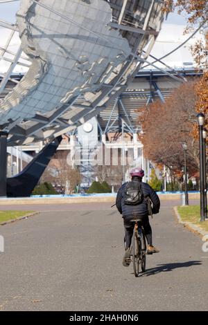 Ein nicht identifizierter Radfahrer fährt mit dem Fahrrad in Richtung Unisphere. Im Flushing Meadows Corona Park in Queens, New York. Stockfoto