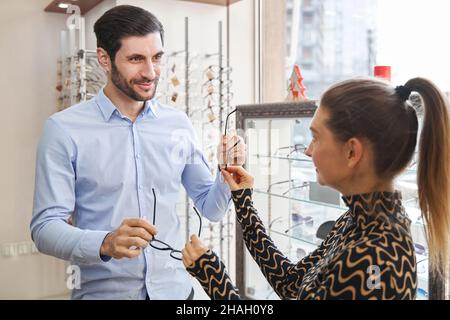 Mann bekommt neue Brillen und gibt ein anderes Modell zurück Stockfoto