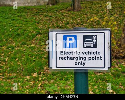 Ein rechteckiges Schild auf einem Stadtparkplatz zeigt einen Parkplatz, der nur für das Aufladen von Elektrofahrzeugen reserviert ist. Stockfoto