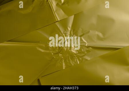 Zerknittertes olivfarbenes Geschenkpapier. Unebene Oberfläche. Abstrakter Hintergrund. Selektiver Fokus. Stockfoto
