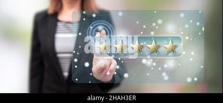 Frau, die ein Konzept für eine Kundenbewertung auf einem Touchscreen berührt Mit den Fingern Stockfoto