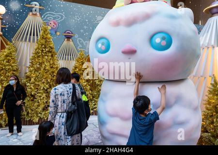 Hongkong, China. 11th Dez 2021. Familie und Besucher genießen ihren Abend am 11. Dezember 2021 bei einer Installation zu Weihnachten in Hongkong. Hongkong ist auf Hochalarm wegen der Ausbreitung der Omicron-Variante während der Feiertage. (Foto von Miguel Candela/SOPA Images/Sipa USA) Quelle: SIPA USA/Alamy Live News Stockfoto