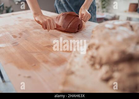 Handwerker, die Tonklumpen im Töpferzimmer teilen Stockfoto