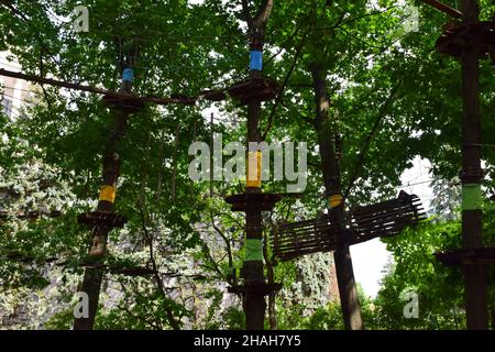 Im Sommerwald, ein Sport-Seilpark Unterhaltung mit Hängebrücken, Übergänge zwischen Bäumen gebunden Stockfoto