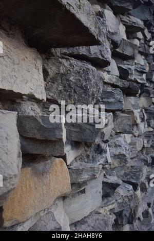 Die Textur des Steins, an der Wand angelegt, in verschiedenen Formen und Schattierungen für den gesamten Rahmen Stockfoto