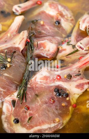 Marinierte Lammschnitzel auf weißem Holzhintergrund. Fleisch Hintergrund. Nahaufnahme von Fleischstücken Stockfoto