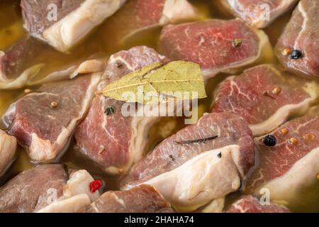 Mariniertes, knochenloses Lammfleisch auf weißem Holzhintergrund. Fleisch Hintergrund. Nahaufnahme von Fleischstücken Stockfoto