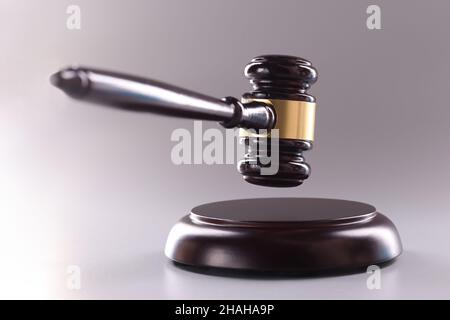 Hölzerner Richter Gavel auf einem grauen Hintergrund Stockfoto