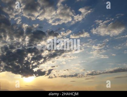 Viele kleine Wolken am ganzen Rahmen, die von unten von der Sonne beleuchtet werden Stockfoto