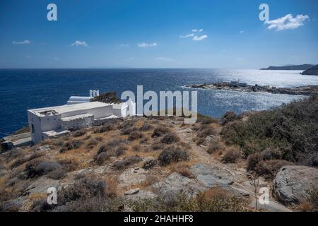 Platis Gialos ist der beliebteste Strand von Sifnos. Der goldene Strand, der sich über tausend Meter erstreckt, ist mit zahlreichen Sonnenliegen und Sonnenschirmen bedeckt, Stockfoto