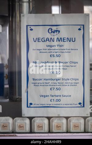 Ein veganes Menü außerhalb eines Fish-n-Chip-Shops, das auf die Nachfrage nach veganem und vegetarischem Essen auf dem Eastbourne Pier in East Sussex, Großbritannien, angepickt ist. Stockfoto