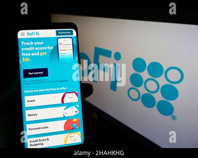 Person mit Smartphone und Website des US-Finanzunternehmens Social Finance Inc. (SoFi) auf dem Bildschirm mit Logo. Konzentrieren Sie sich auf die Mitte des Telefondisplays. Stockfoto