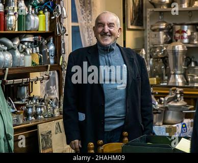 Kader Zennaf lächelt breit vor den überfüllten Regalen seiner privaten Aluminiumsammlung im Haus seiner verstorbenen Mutter in Saint-Chamond, Département Loire, Frankreich. Er begann als Kind zu sammeln, nachdem er selbst eine kleine Kaffeetasse aus dem französischen Leichtmetall geschenkt bekommen hatte. Stockfoto