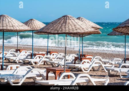 Der Strand mit Sonnenschirmen und Liegestühlen ist während eines Sturms leer Stockfoto