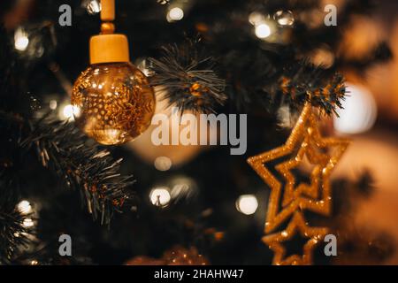 Festlicher Weihnachtsbaum mit golden glänzenden Weihnachtsspielzeug mit goldenen Sternen verziert. Winterfeiertag. Neujahr magische Winter Tapete Stockfoto