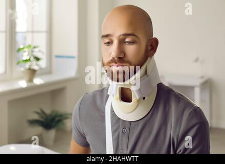 Verletzter Kerl mit chirurgischer Nackenbandage nach Trauma Stockfoto