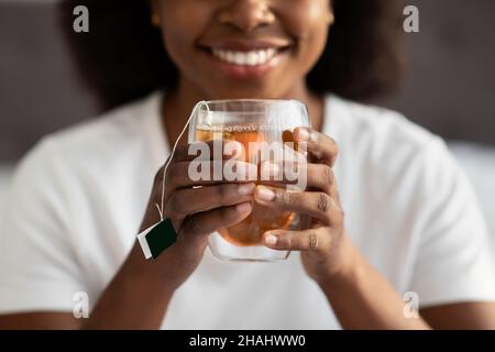 Weibliche Hände halten Tasse mit heißem Getränk, abgeschnitten Stockfoto
