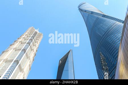 Shanghai Tower (rechts), Shanghai World Financial Center (Mitte) und Jinmao Tower (links), die drei höchsten Gebäude Shanghais gegen blauen Himmel Stockfoto