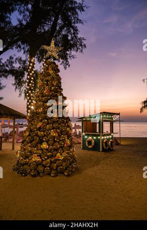 Na Jomtien Beach Pattaya Thailand, weißer tropischer Strand bei Sonnenuntergang in Pattaya Najomtien. Weihnachtsbaum am Strand mit Kokosnüssen Stockfoto