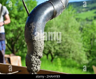 Detail einer Betonpumpe, aus der Beton in Wände auf der Baustelle geschüttet wird Stockfoto