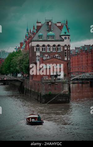 OLDENBURG, DEUTSCHLAND - 27. Sep 2021: Eine vertikale Aufnahme eines Bootes vor der Hamburger Speicherstadt Stockfoto