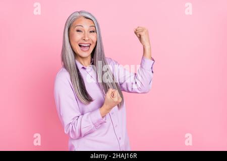 Porträt von attraktiven glücklich fröhlich grauhaarige Frau jubeln Spaß isoliert über rosa Pastellfarben Hintergrund Stockfoto