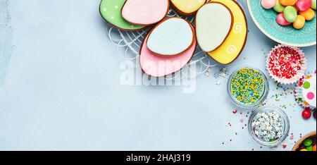 Ostern Backen Hintergrund. Ostern bunten Lebkuchen, Süßigkeiten und Süßwaren Topping Dressing auf blauem Hintergrund. Festliches Hintergrundkonzept Stockfoto