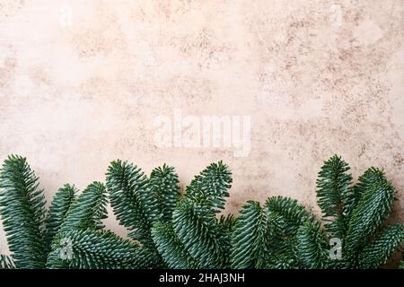 Weihnachtsdekoration. Weihnachtsdekorationen mit Kugeln, Tannenzweigen und auf altem grauen Hintergrund. Bordüre. Draufsicht. Stockfoto