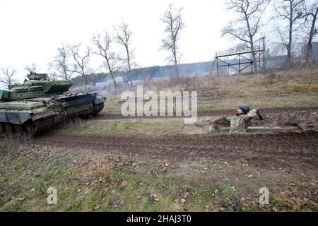 REGION CHARKIW, UKRAINE - 11. DEZEMBER 2021 - Ein Mann wirft eine Granate auf einen Panzer während der Übungen der territorialen Verteidigungseinheiten in der Region Charkiw, n Stockfoto