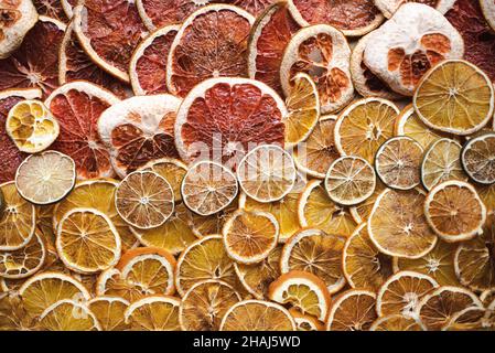 Getrocknete Zitrusscheiben, Orange, Grapefruit und Limette, Vorbereitung für natürliche Zitrusgirlanden für die Weihnachtsdekoration, Wintersonnenwende, yule-Dekor Stockfoto