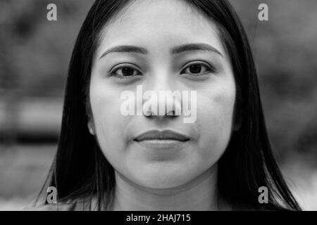 Asiatische junge Frau, die ernsthaft vor der Kamera schaut - Fokus auf Gesicht Stockfoto