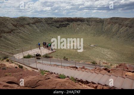 Eine Gruppe von Menschen auf der Aussichtsplattform am Meteor-Krater in der Nähe von Winslow im Norden von Arizona, USA. Der Krater zeigt umgestrichenem, geschichteten Sandsteinfelsen Stockfoto