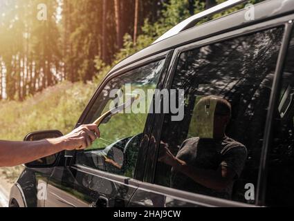 Männer Hand mit Auto-Gummi-Wischer, sauberer Reinigung Auto Fenster im Freien. Stockfoto