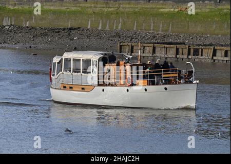 Sigrid von Chelsea, eine Motoryacht, die 1925 von Camper und Nicholson gebaut wurde, macht sich an einem Dezembernachmittag auf den Weg entlang der Themse in der Nähe der Vauxhall Bridge Stockfoto