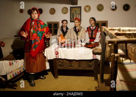 USCHHOROD, UKRAINE - 10. DEZEMBER 2021 - Frauen in traditionellen ukrainischen Kostümen führen die Andriivski-Vecchornytsi-Feier auf der Reg Stockfoto